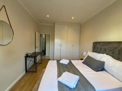 a bedroom with a bed with two pillows on it at Elegant, Relaxing Gateway House in Cape Town in Cape Town
