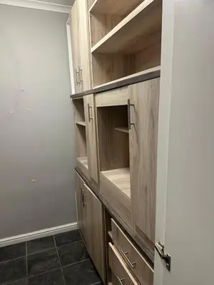 a closet with wooden cabinets in a room at Bell rose oaks guest house in Blomtuin