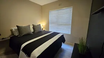 a bedroom with a large bed and a window at Her Sanctuary in Cape Town