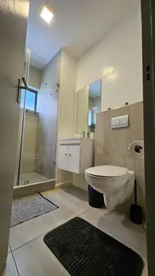 a bathroom with a shower and a toilet and a sink at Her Sanctuary in Cape Town