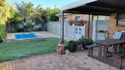 a backyard with a picnic table and a swimming pool at Waaigras in Brackenfell
