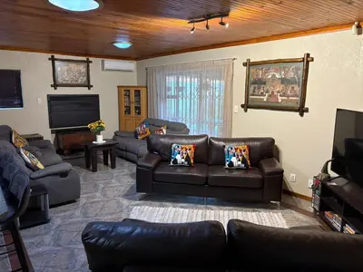 a living room with leather furniture and a flat screen tv at Waaigras in Brackenfell
