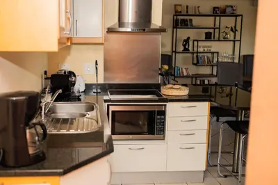 a kitchen with a sink and a microwave at De Wingerd Wijnland Lodge in Paarl