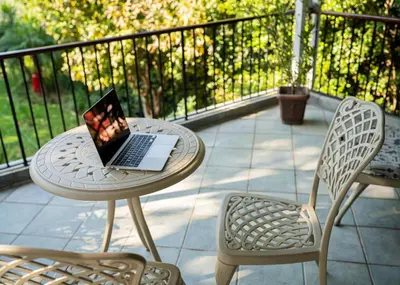 a laptop computer sitting on a table on a patio at De Wingerd Wijnland Lodge in Paarl