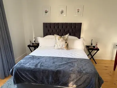 a bedroom with a large bed and two night stands at Peaceful coastal holiday home in Hermanus