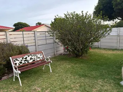 a bench sitting in a yard next to a fence at Peaceful coastal holiday home in Hermanus