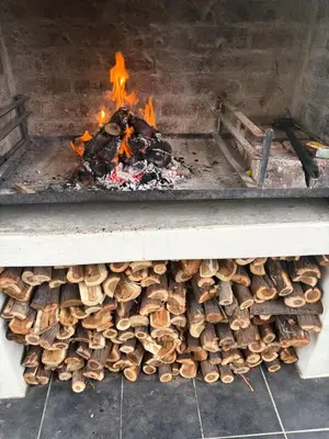 a pile of fire wood in a grill at Peaceful coastal holiday home in Hermanus