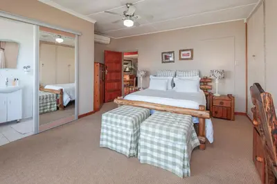 a bedroom with a large bed and a sink at 18 On Kloof Guest House in Gordonʼs Bay