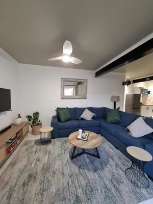 a living room with a blue couch and a table at Embrace This Planet Self-Catering Accommodation in Fisherhaven