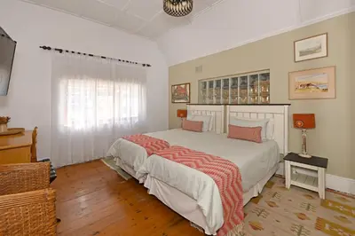 a bedroom with a large bed and a window at Mawethu on Mead Guesthome with Covered pool and Garden in Cape Town