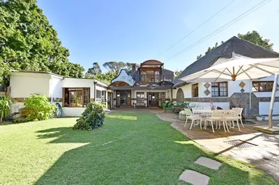 an image of a house with a lawn at Mawethu on Mead Guesthome with Covered pool and Garden in Cape Town