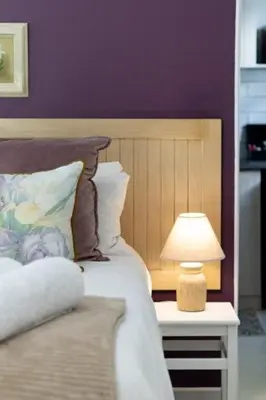 a bedroom with a bed with a lamp on a table at Five Mountains Guest Farm & Spa in Wellington