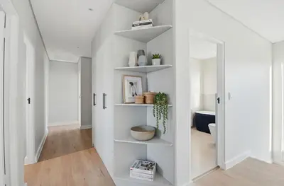 a hallway with white walls and white shelves at Cape Signature Villa in Cape Town
