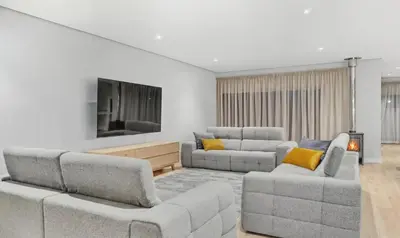 a living room with two couches and a flat screen tv at Cape Signature Villa in Cape Town