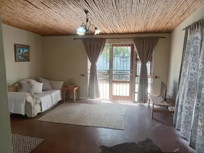 a bedroom with a bed and a large window at Starfish Cottage in Kleinmond