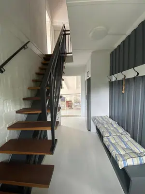 a staircase in a house with a couch on the floor at Joan's Sea Cottage in Pringle Bay