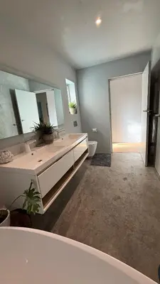 a bathroom with a sink and a large mirror at Large and spacious family home is leafy suburb in Stellenbosch