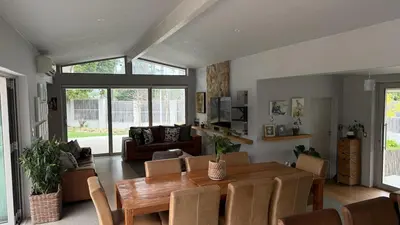 a living room with a table and a couch at Large and spacious family home is leafy suburb in Stellenbosch