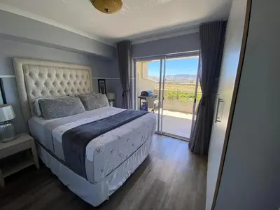 a bedroom with a large bed and a large window at Opulent Home Stay in Cape Town