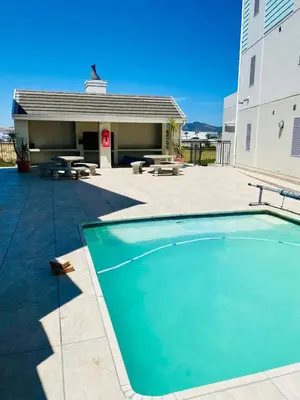 a large swimming pool in front of a building at Opulent Home Stay in Cape Town