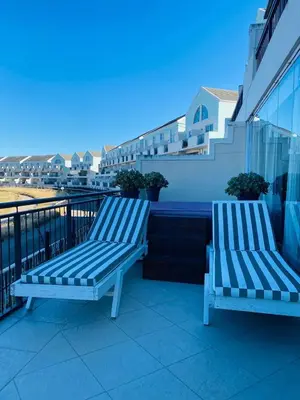 two blue benches sitting on a balcony with a view at Opulent Home Stay in Cape Town