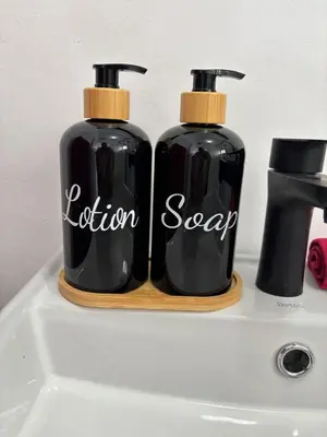 two black bottles of soap sitting on top of a sink at Layover on Loerie in Cape Town