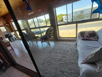 a living room with a bed and a table and chairs at HuisieBydieC in Hermanus