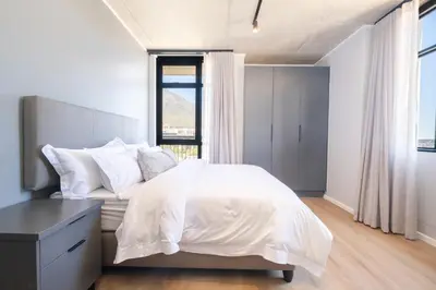 a bedroom with a white bed and a window at 311 Riverlands - Lux 2 Bedroom Apartment in Cape Town