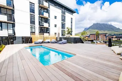 an apartment patio with a swimming pool and a building at 311 Riverlands - Lux 2 Bedroom Apartment in Cape Town