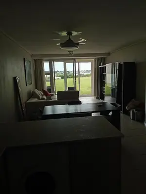a living room with a couch and a table at Spacious Beachfront 2bedroom apartment lagoon view in Cape Town