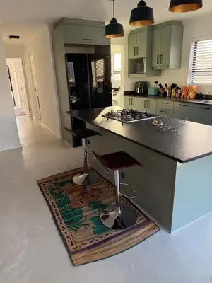 a kitchen with a black counter and a rug on the floor at Mountain View 2-Bedroom Home Near the Beach in Pringle Bay in Pringle Bay
