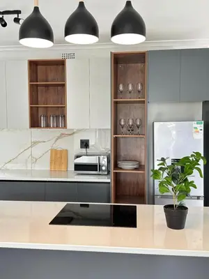a kitchen with white cabinets and a counter with a plant at Lux City Haven in Cape Town