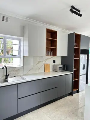 a kitchen with white cabinets and a sink at Lux City Haven in Cape Town