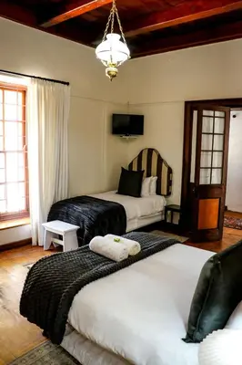 a bedroom with two beds and a chandelier at Palm La Vie in Worcester