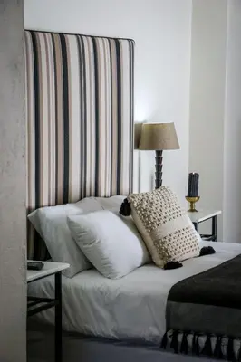 a bed with pillows on it with a striped wall at Palm La Vie in Worcester