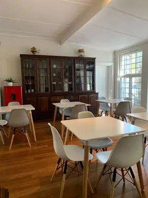 a group of tables and chairs in a room at Just Joey Lodge in Stellenbosch