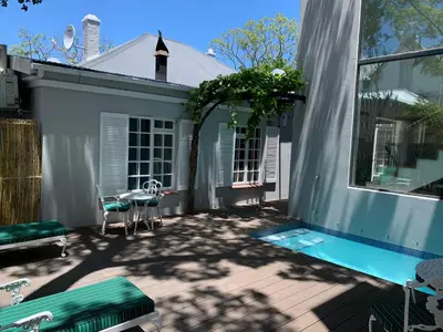 a patio with a swimming pool next to a house at Just Joey Lodge in Stellenbosch
