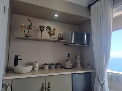 a kitchen with a counter with chickens on the wall at Boutique Inn - Serenity in Gordonʼs Bay