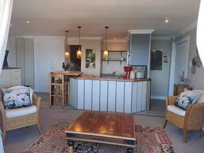 a kitchen with a table and a counter top at Boutique Inn - Whale Pod in Gordonʼs Bay