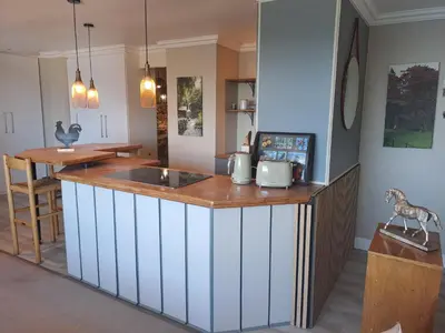 a kitchen with an island with a counter top at Boutique Inn - Whale Pod in Gordonʼs Bay