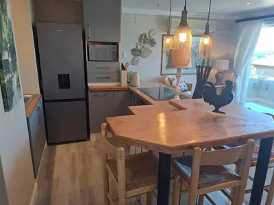 a kitchen with a wooden table and chairs in a kitchen at Boutique Inn - Whale Pod in Gordonʼs Bay