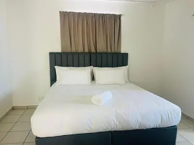 a bed with a towel on top of it at Eversham Boutique in Cape Town