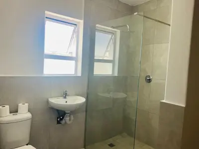a bathroom with a shower and a toilet and a sink at Eversham Boutique in Cape Town