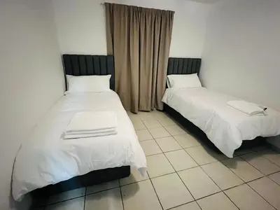 two beds sitting next to each other in a room at Eversham Boutique in Cape Town
