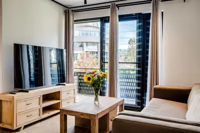 a living room with a couch and a tv and a table at Palmcrest Eden in Cape Town