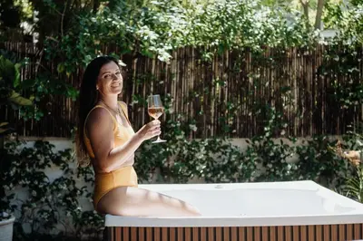 a woman in a bathing suit holding a glass of wine at Onrus Sunshine Beach Days in Hermanus