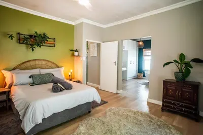 a bedroom with a bed and a green wall at Onrus Sunshine Beach Days in Hermanus