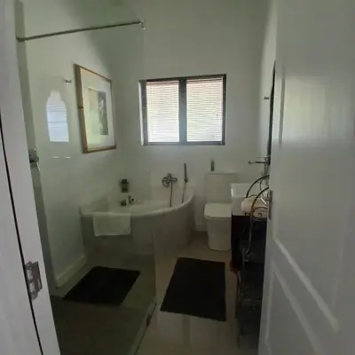 a white bathroom with a tub and a toilet at Awesome cottage, stone throw from cliff path, golf, restaurant in Hermanus