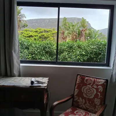 a window in a room with a chair and a table at Awesome cottage, stone throw from cliff path, golf, restaurant in Hermanus
