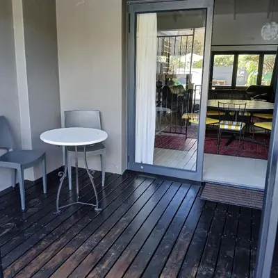 a room with a table and chairs and a patio at Awesome cottage, stone throw from cliff path, golf, restaurant in Hermanus